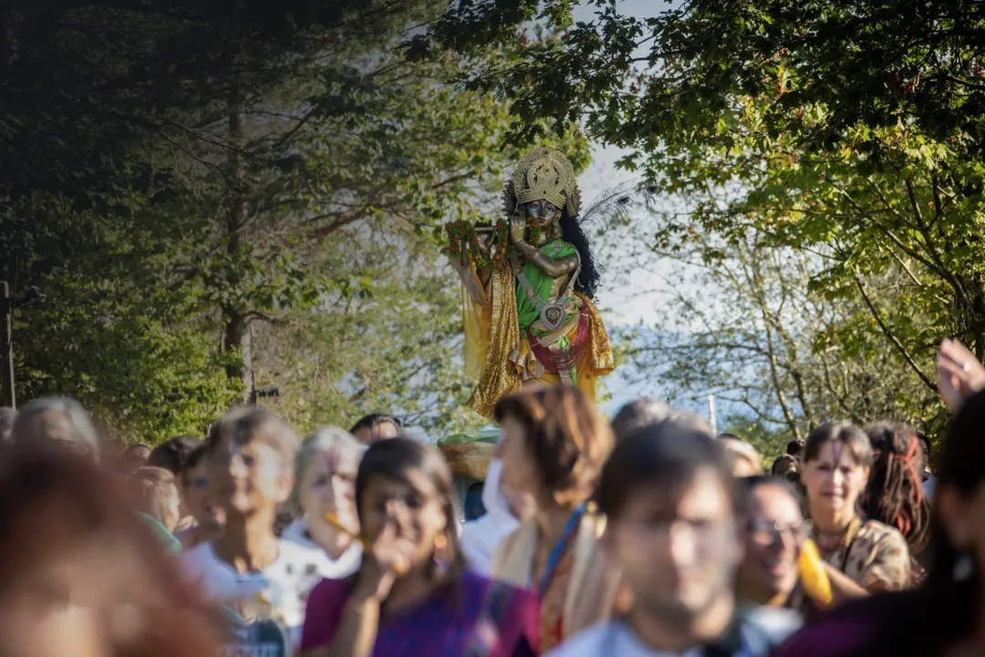 people performing procession with hindu deity Krishna