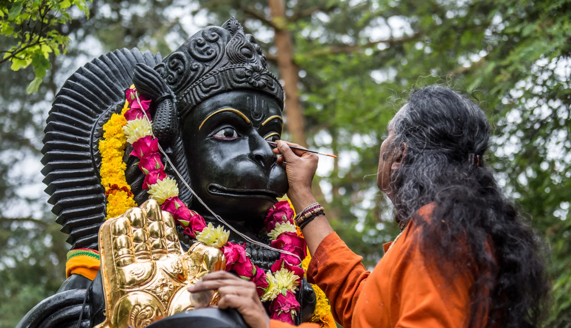 paramahamsa vishwananda painting a tilak over the hindu deity hanuman