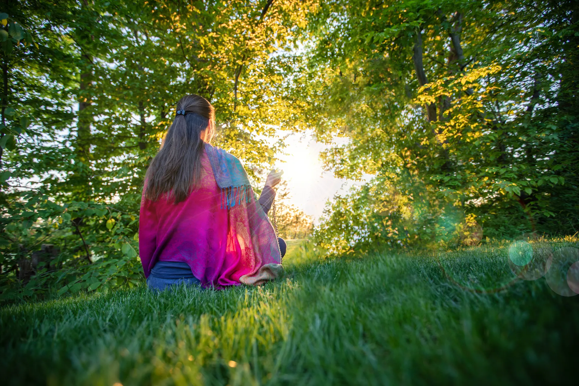 woman sitting in the nature and doing japa meditation